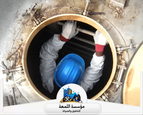 تنظيف الخزان الأرضي بالرياض 0530613269 اللمعة عامل يرتدي ملابس واقية وخوذة ينزل لتنظيف خزان مياه، تابع لمؤسسة اللمعة للصيانة والتشغيل بالرياض.